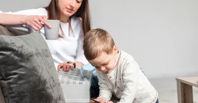 Majka promatra dijete koje istražuje i uči kroz igru – važnost ranog razvoja i roditeljske podrške