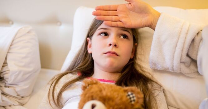 Majka mjeri temperaturu djetetu s vanjskom stranom dlana